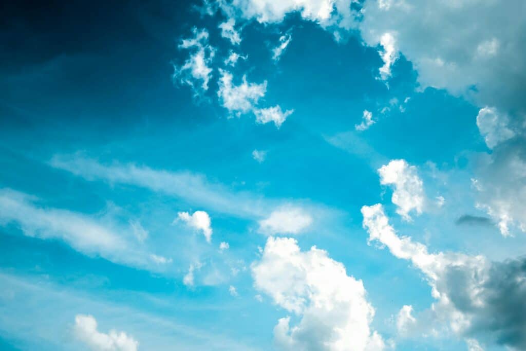 Vivid blue sky background with contrasting white clouds, perfect for atmospheric themes.