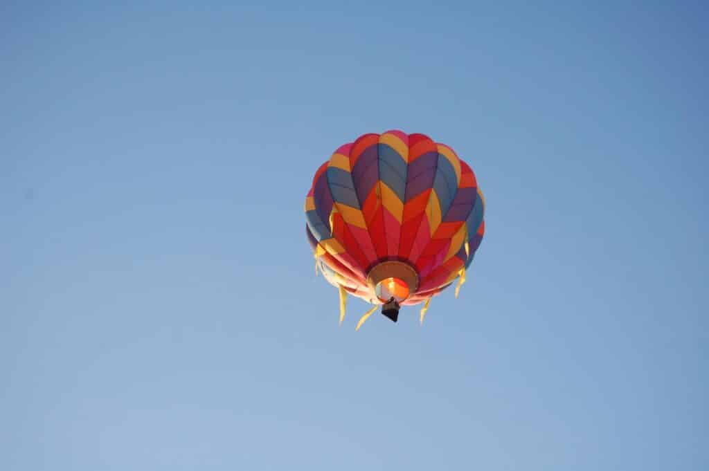 Colorful hot air balloon soaring in a clear blue sky, symbolizing freedom and adventure.
